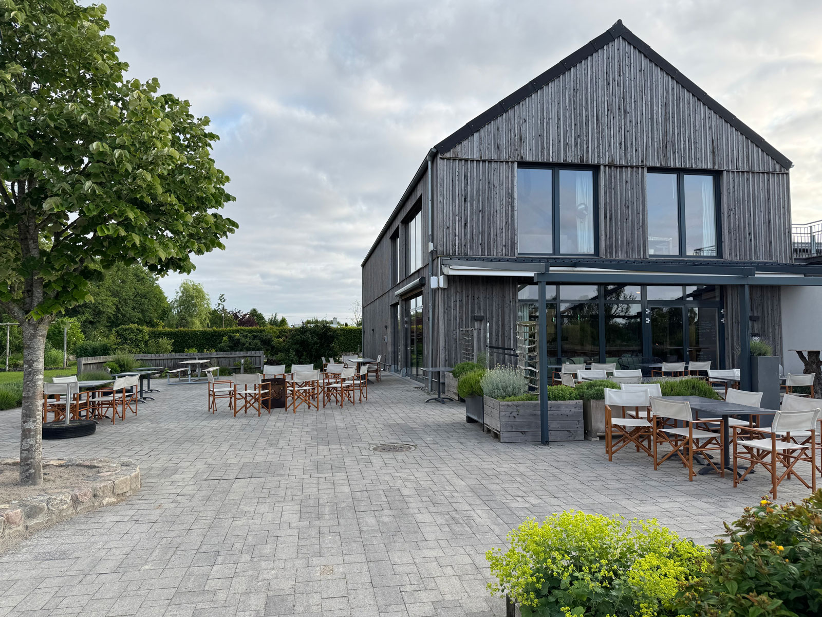 Terrasse und moderne Holzfassade des Biohof Bakensholz bei mildem Abendlicht